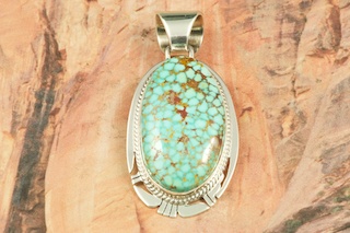 Genuine High Grade Kingman Web Turquoise set in Sterling Silver Pendant. Created by Navajo Artist Phillip Sanchez. Signed by the artist. The Mineral Park Mine, in the Cerbat Mountains 14 miles northwest of Kingman, was first mined by Indians centuries before white man came to the area. It is one of the three sites of prehistoric mining localities in the state of Arizona. Mineral Park was the most extensively worked area by the Indians of the three. S.A. �Chuck� Colbaugh found a cache of stone hammers uncovered in ancient trenches and tunnels, when he had the turquoise mining concession in May of 1962. Ithaca Peak and Turquoise Mine (formally called Aztec Mountain or Aztec Peak) are the most famous of the peaks in the area containing turquoise. Free 18